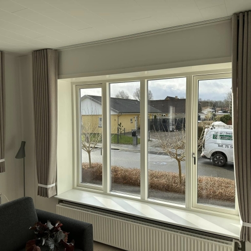 Klassiske stofgardiner i beige nuance monteret i lys stue - gardiner Toftlund